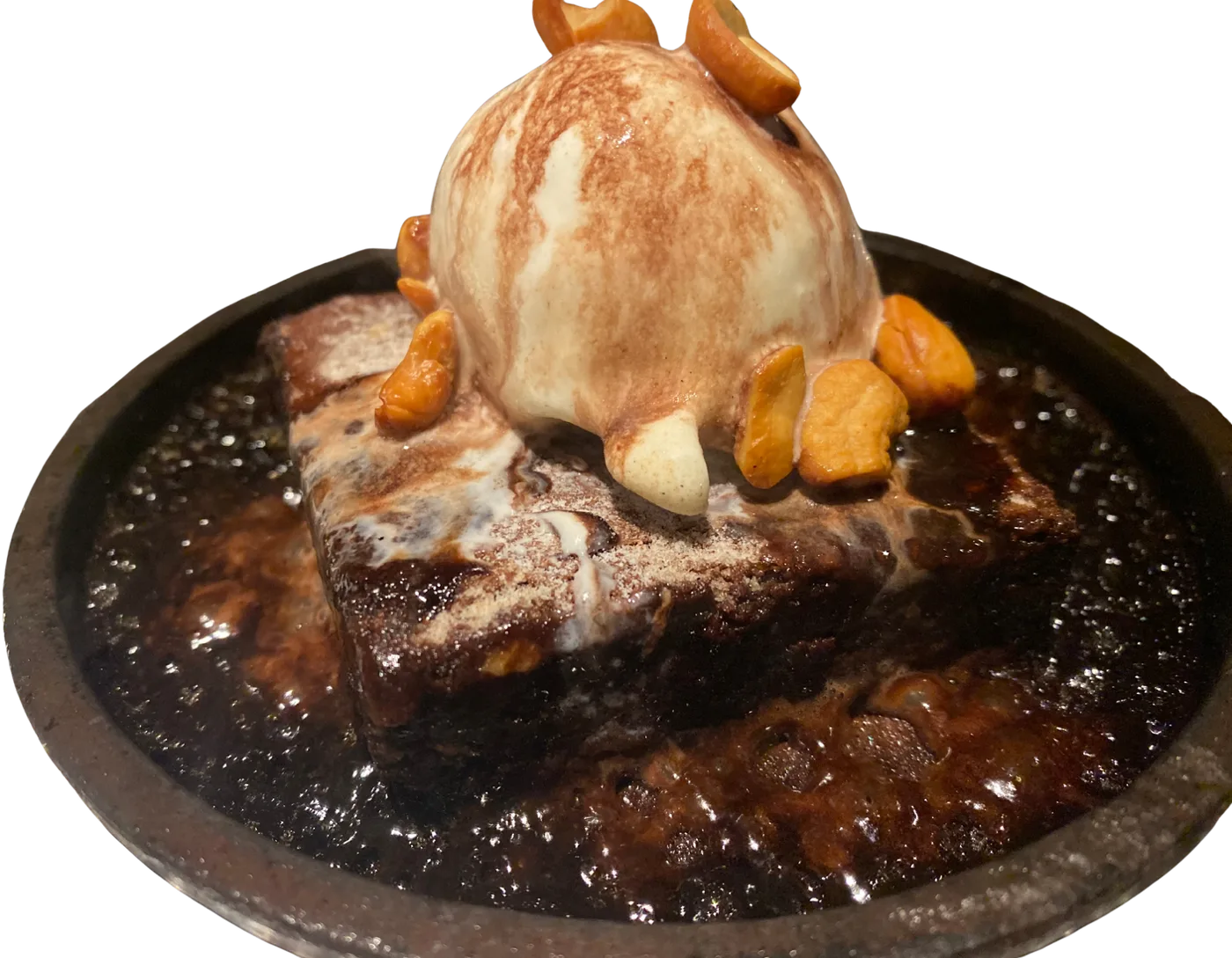 Sizzling brownie with ice cream on a hot iron plate
